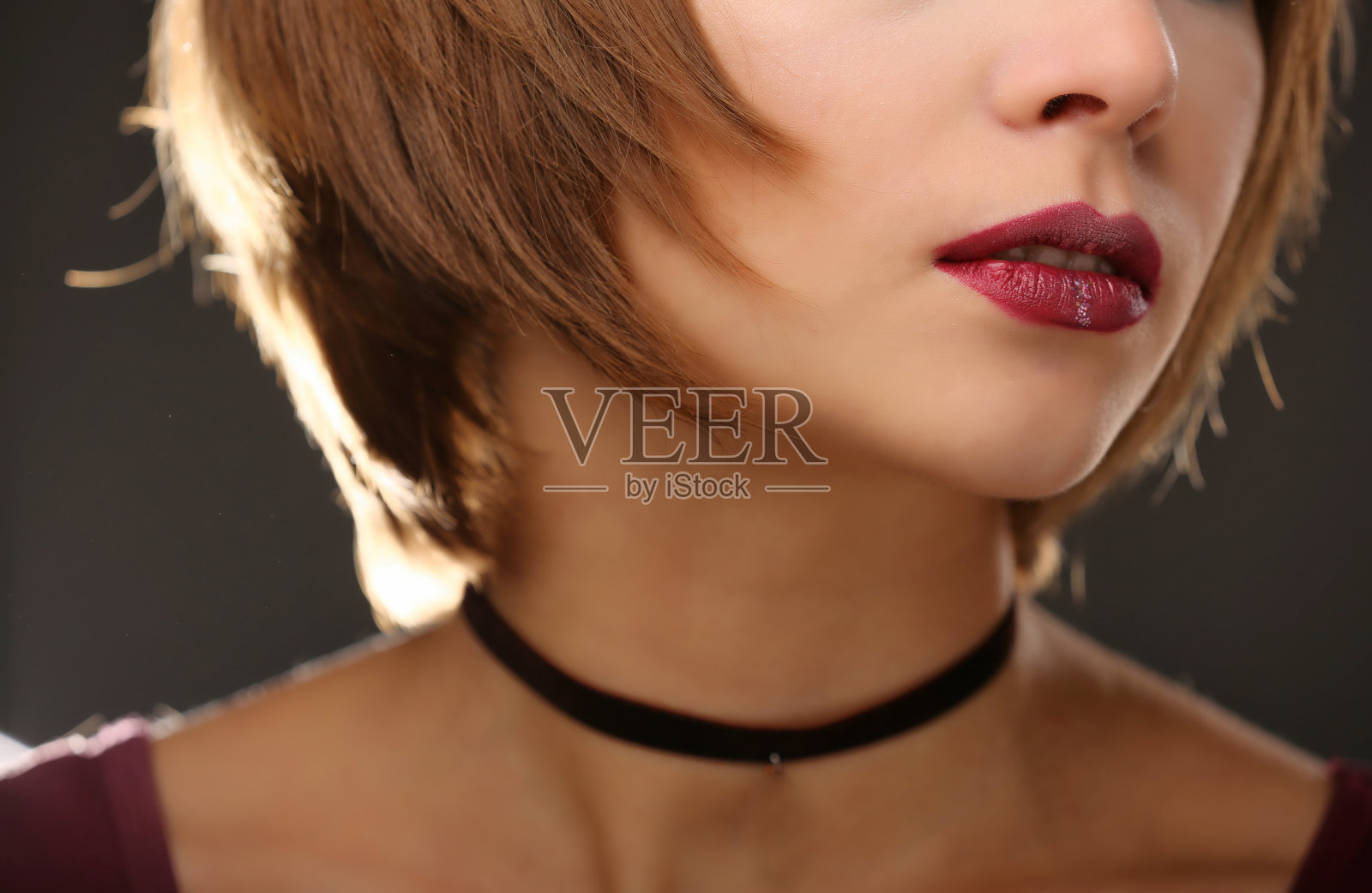 红袍女人的嘴唇合上了。年轻的红头发女人的肖像与时尚的化妆。照片摄影图片