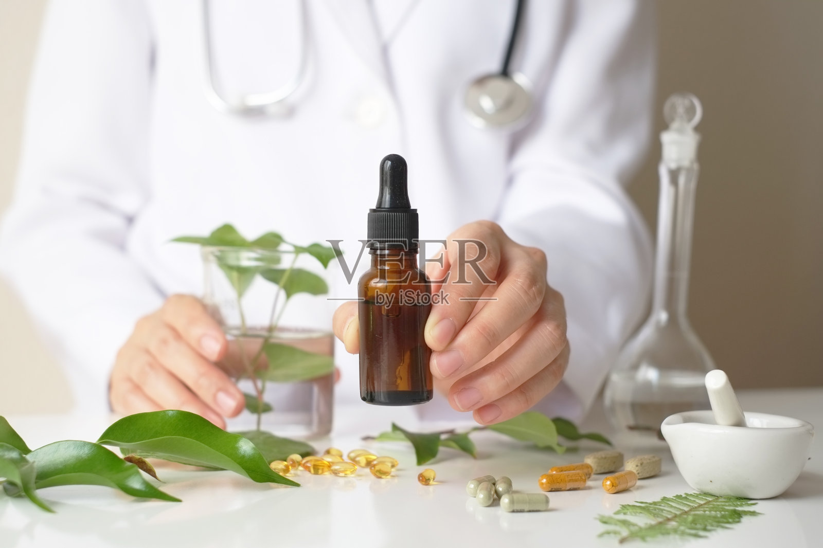 科学家或医生在实验室的桌子上用草药制成草药。替代疗法。出示手和听诊器。与瓶子容器。照片摄影图片