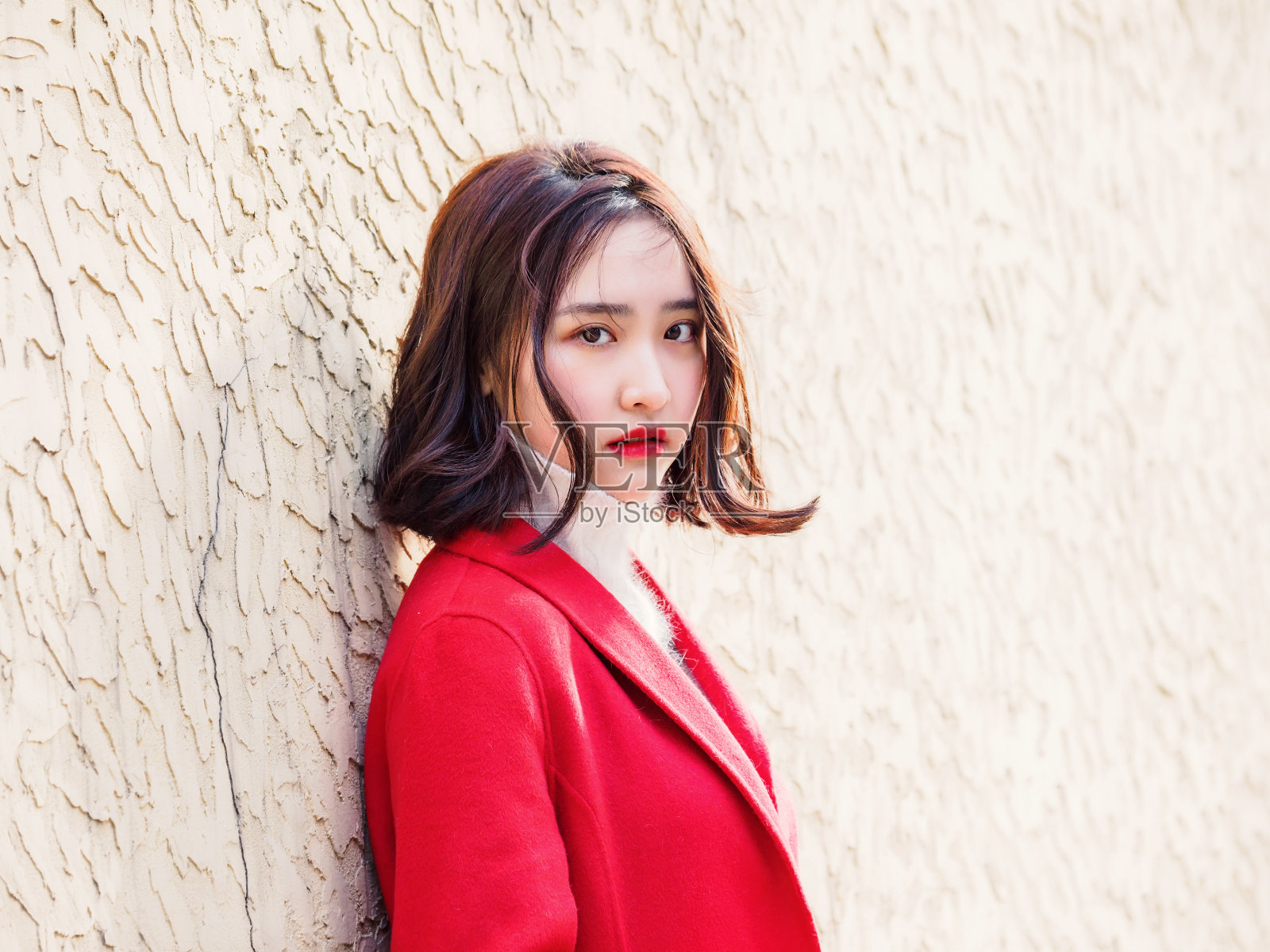 在秋天的城市里，穿着红色外套的漂亮年轻女子。户外时尚写真魅力年轻的中国开朗时尚女士在街头。情感、人、美、生活理念。照片摄影图片