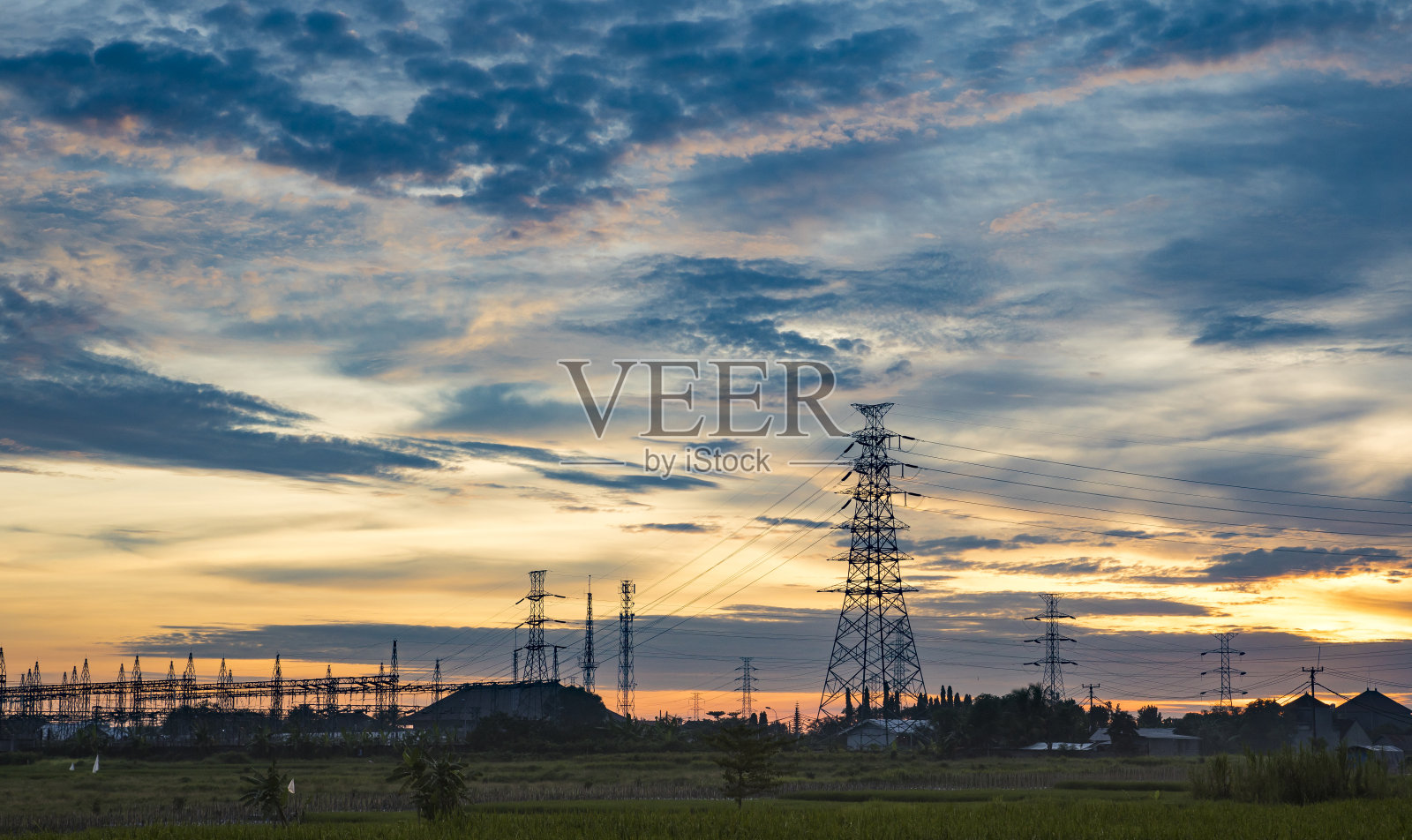 高压电塔后的壮丽日落照片摄影图片