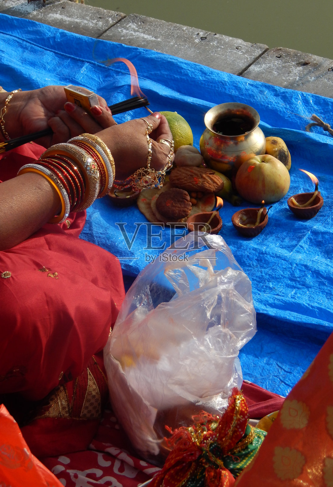 印度信徒提供普拉萨，水果，蔬菜和其他项目和灯或diya，祈祷太阳神，在一个湖，在Chhath Puja节照片摄影图片