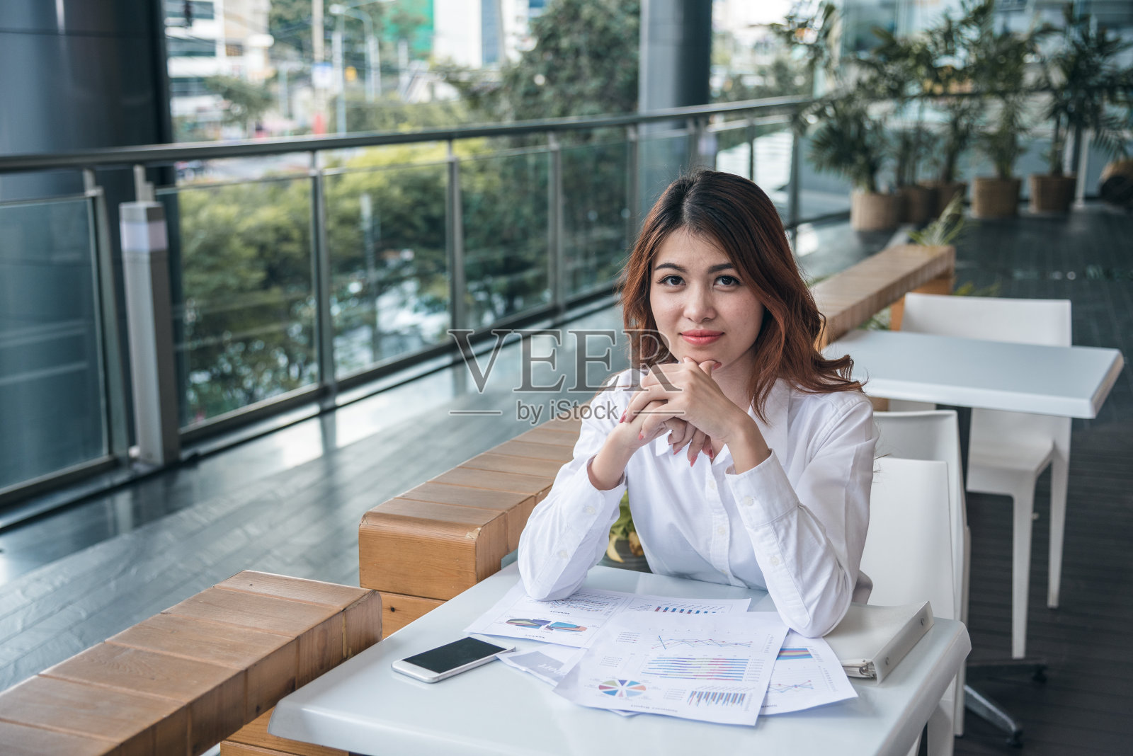 美丽的亚洲女人的肖像看起来愉快和自信的坐和感觉与工作的成功。照片摄影图片
