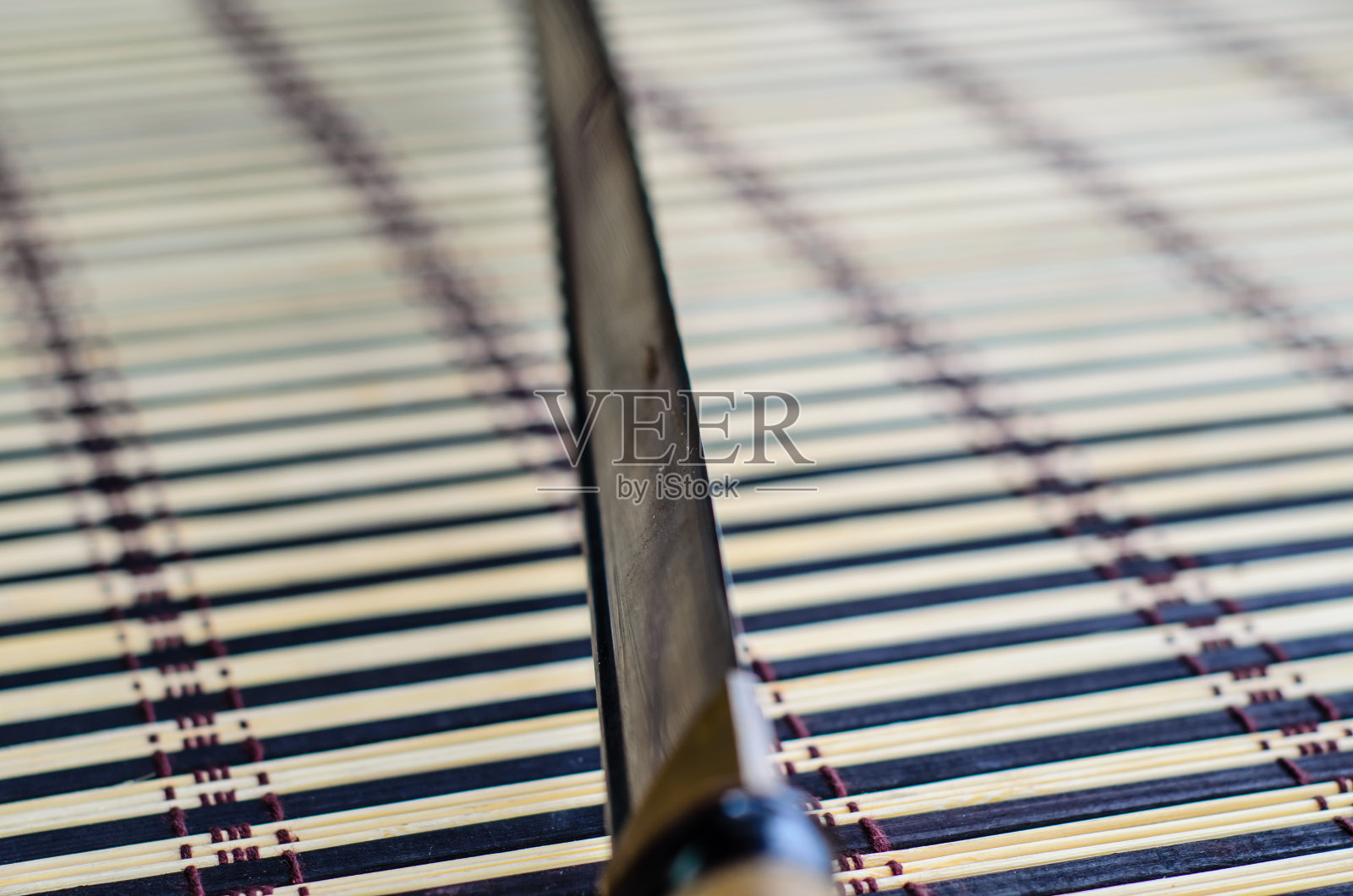 竹席上的日本武士刀。选择性聚焦照片摄影图片
