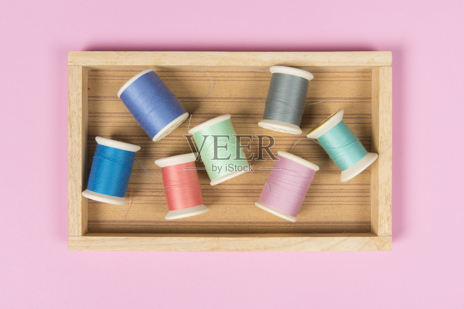 平铺彩色线卷，用于在黄色背景上缝制，缝纫和刺绣概念。照片摄影图片