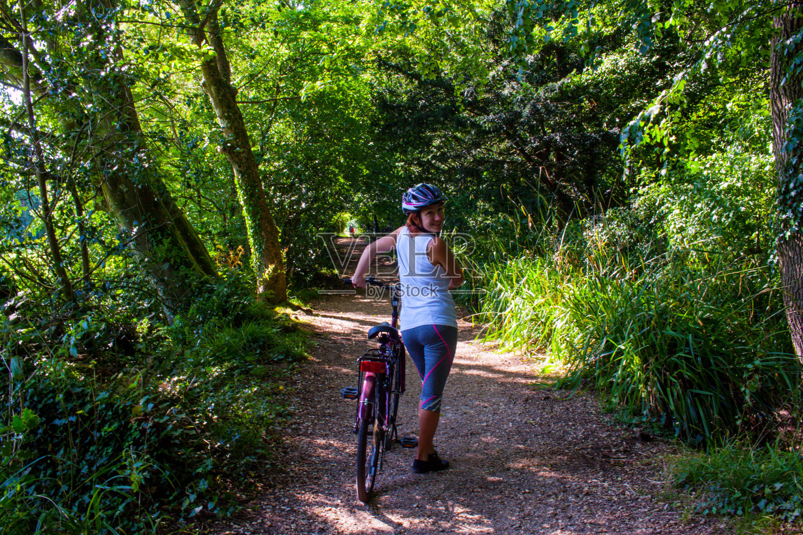 女人在森林里骑自行车照片摄影图片