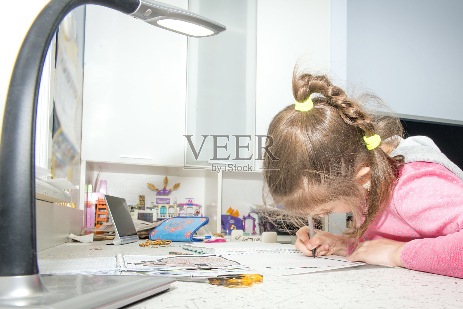 这个女孩在盒子里的笔记本上画毡尖笔。照片摄影图片