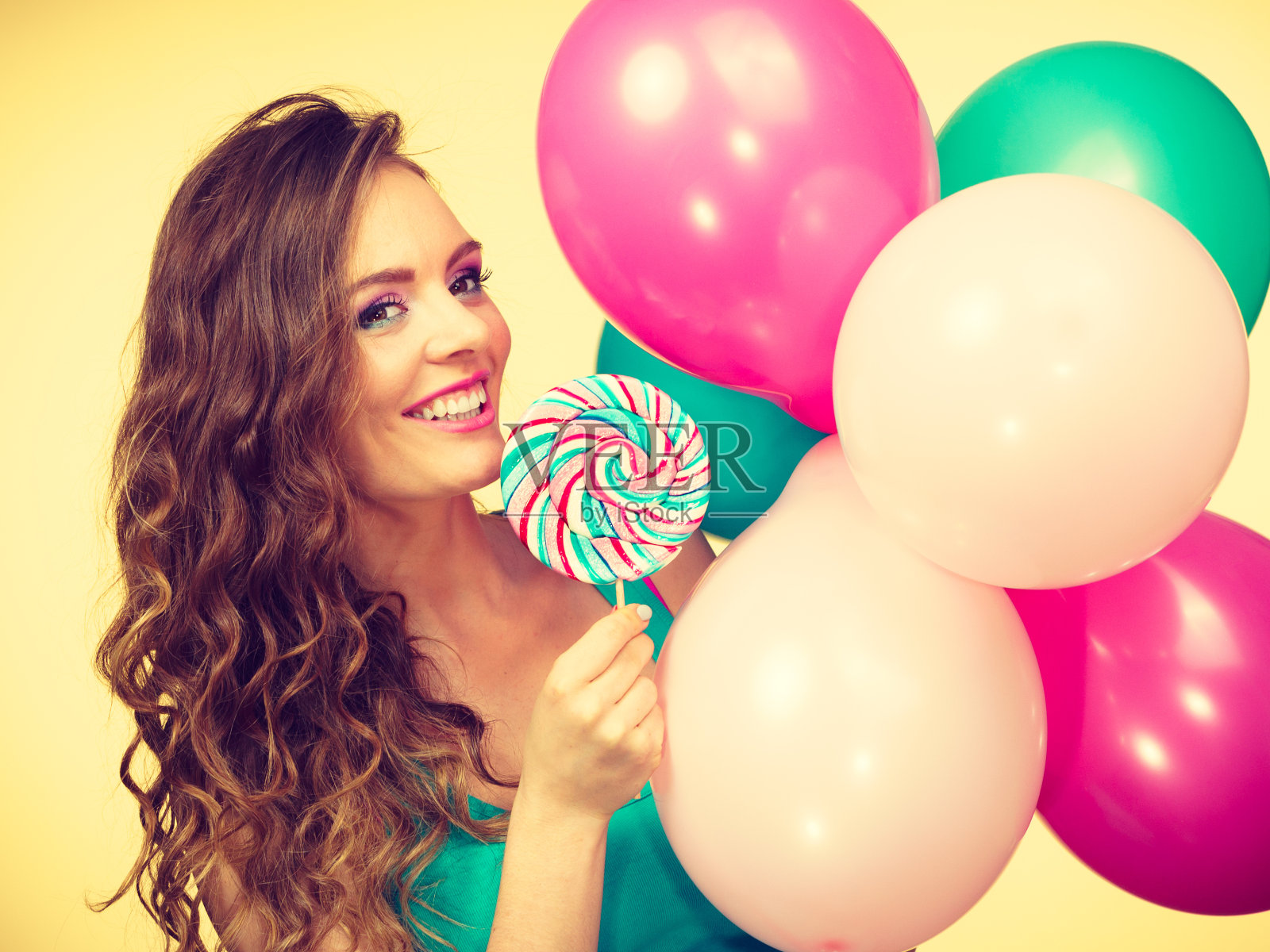 拿着彩色气球和棒棒糖的女人照片摄影图片