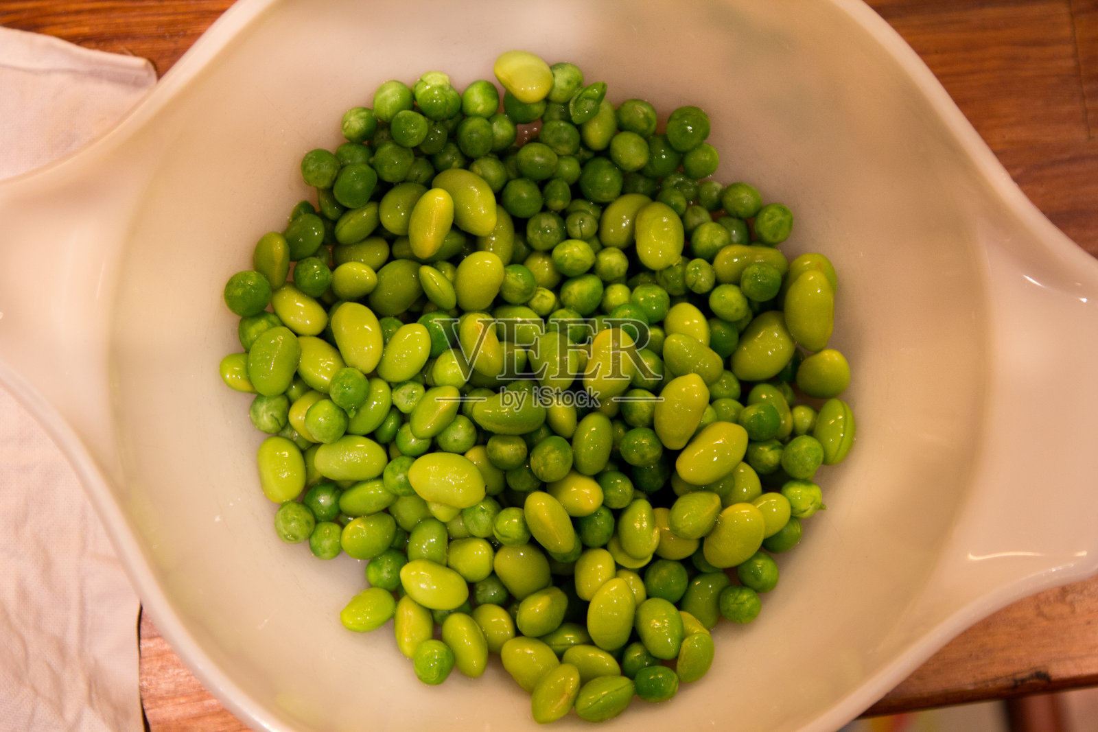 一碗装着豌豆和大豆的白色陶瓷碗照片摄影图片