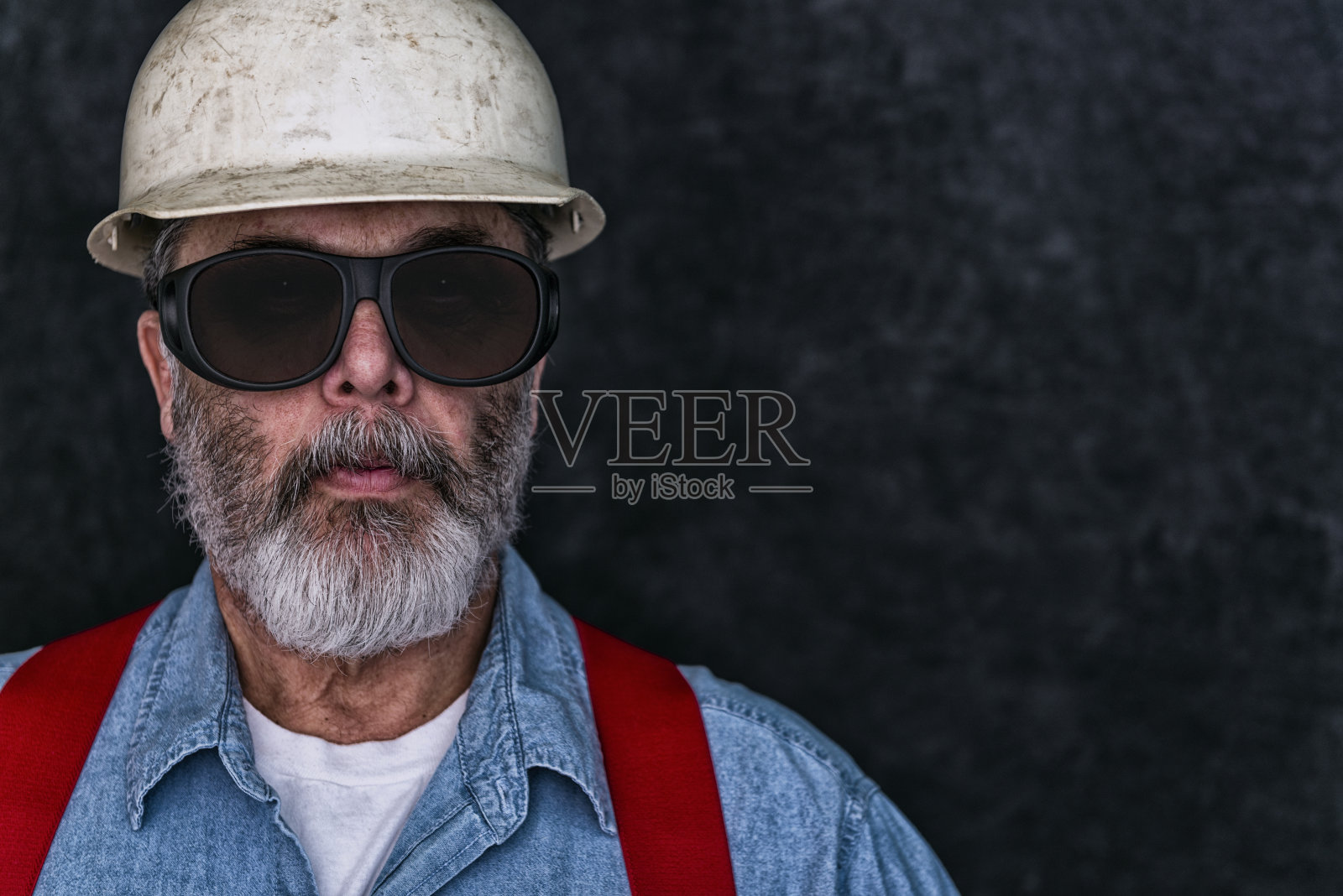 一个建筑工人在黑暗背景下的肖像照片摄影图片