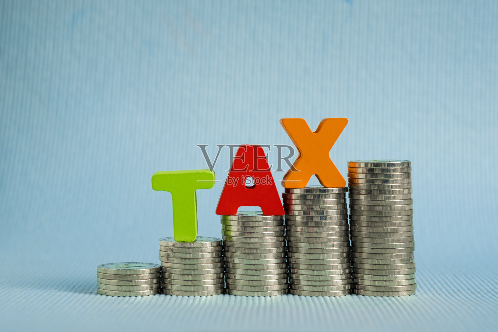 税收的概念。字税务字母由木材与硬币堆叠，商业和金融概念。照片摄影图片