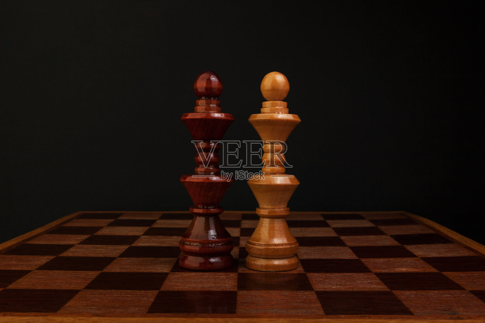 国际象棋。黑与白的国王在木板上。照片摄影图片