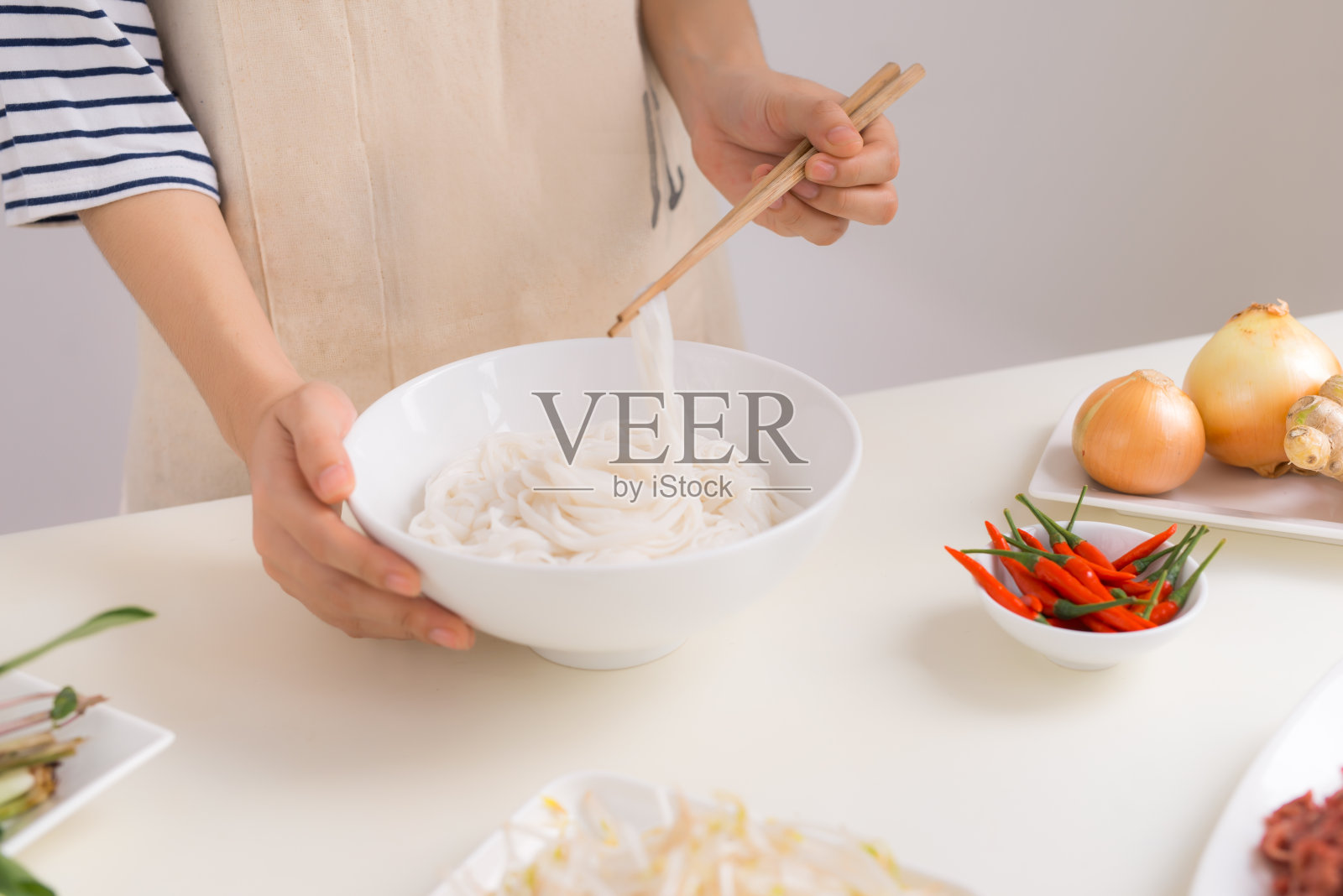 女厨师准备传统的越南汤越南河粉与香草，肉，米粉照片摄影图片