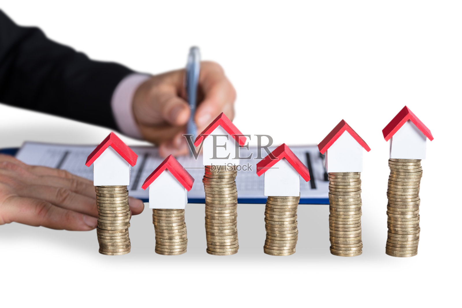 房子模型上堆叠的硬币照片摄影图片