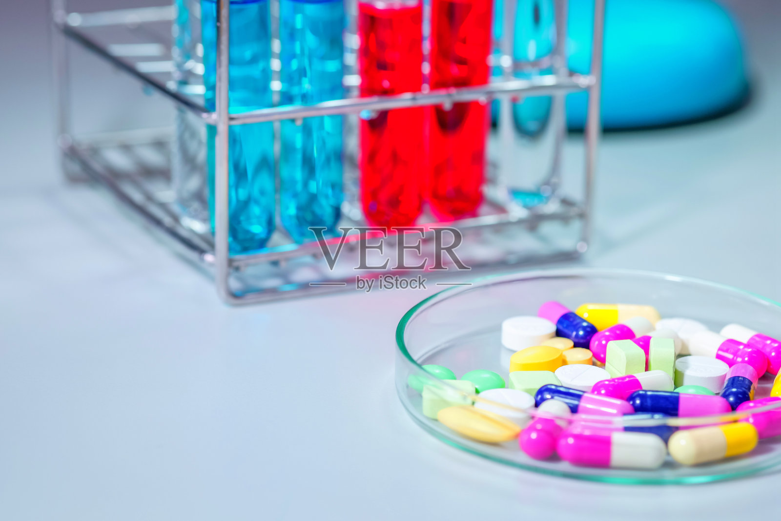 药片放在桌子上，彩色液体装在玻璃器皿里照片摄影图片