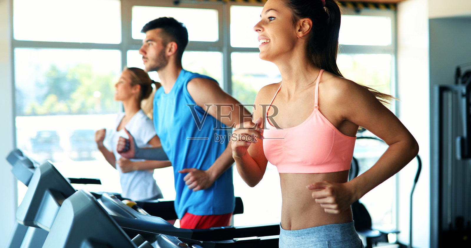 人们在健身房跑步机上跑步的照片照片摄影图片