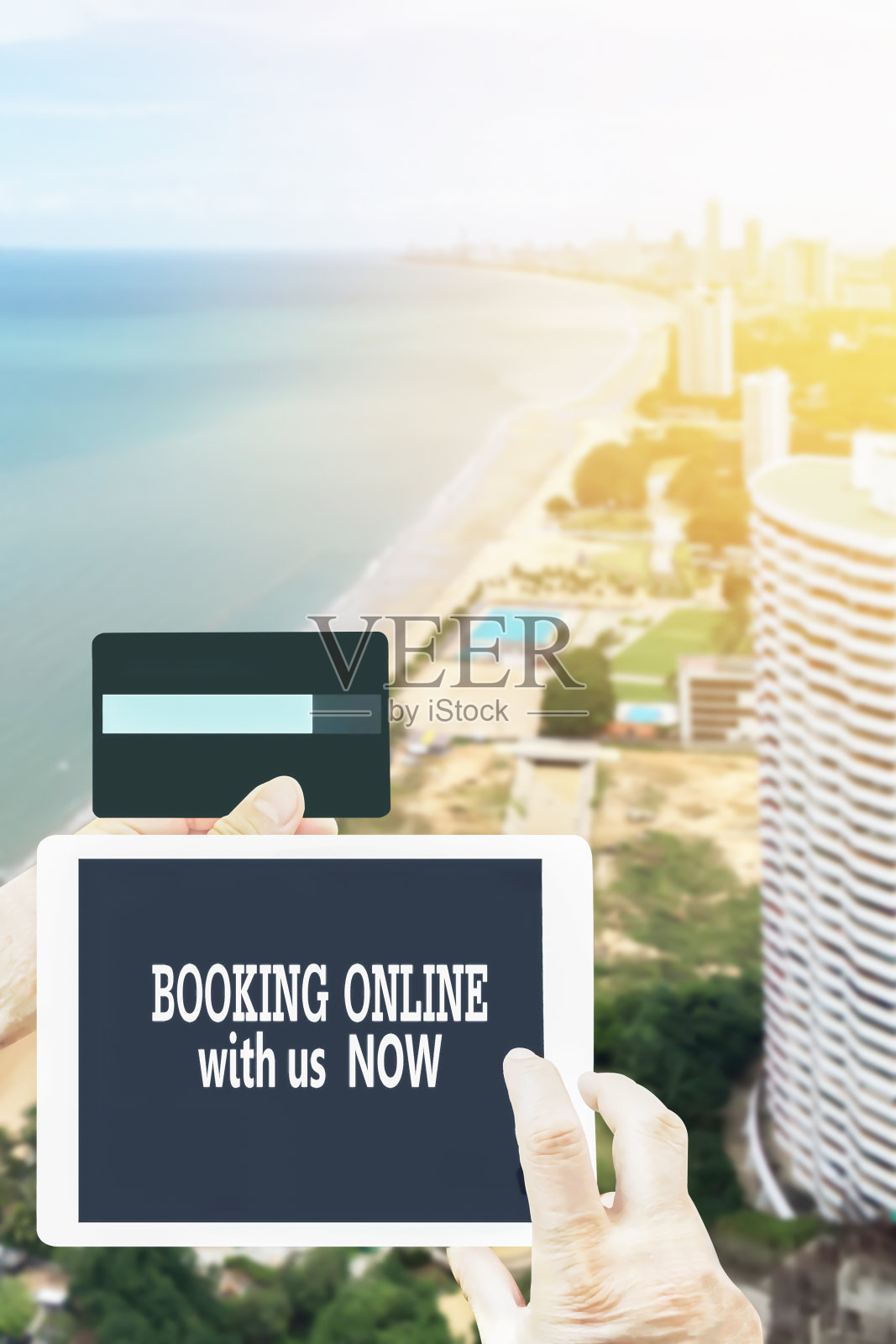 在线预订系统的度假度假旅游平板电脑手持信用卡和美丽的鸟瞰图背景。照片摄影图片
