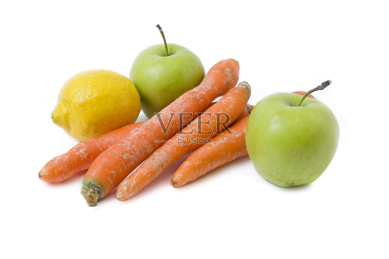 白色背景上的水果。青苹果和胡萝卜。柠檬，苹果和胡萝卜在白色的背景。照片摄影图片