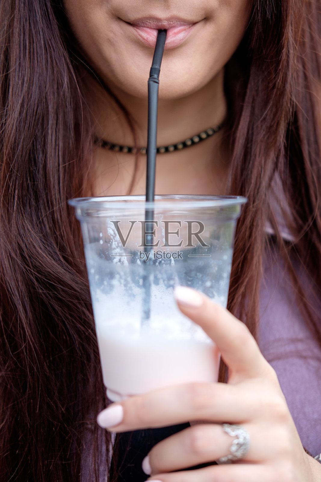年轻漂亮的黑发女人喝着牛奶鸡尾酒照片摄影图片