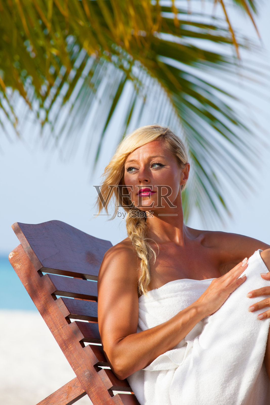 年轻的金发女孩在日光浴床上照片摄影图片