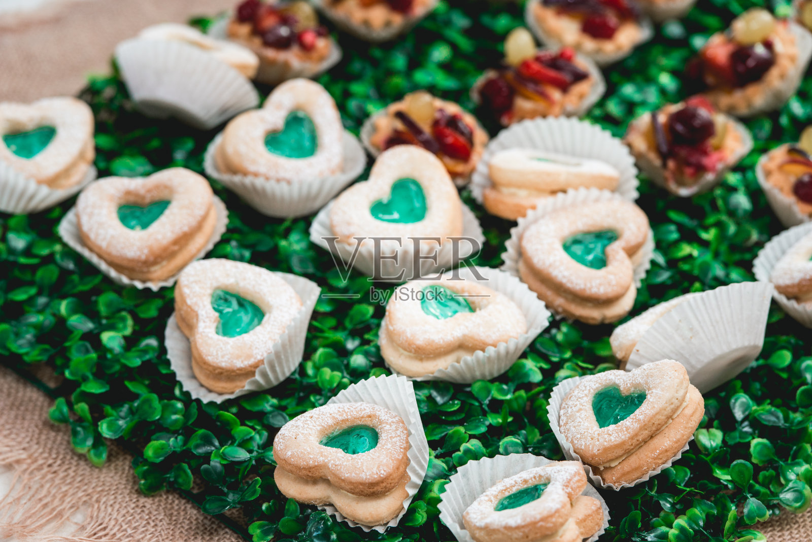 美味的饼干心，甜蜜的彩色甜点，绿色和白色的生日派对上的糖果棒照片摄影图片