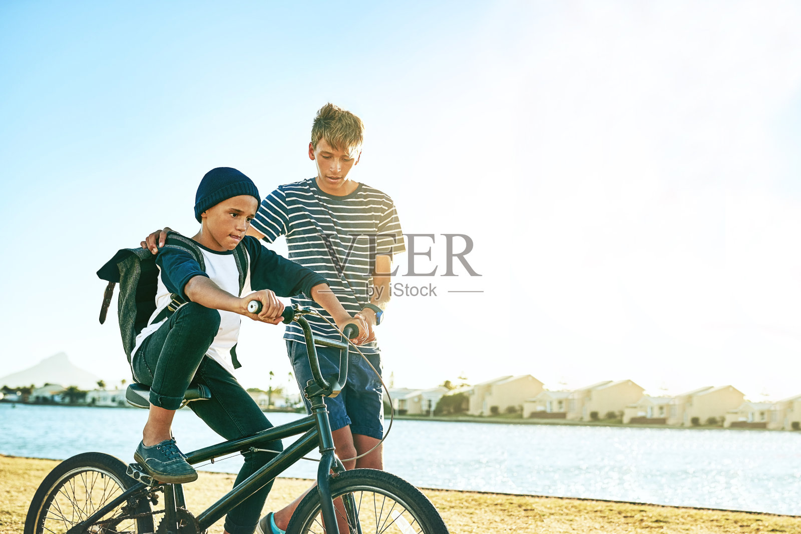 教他弟弟骑自行车照片摄影图片