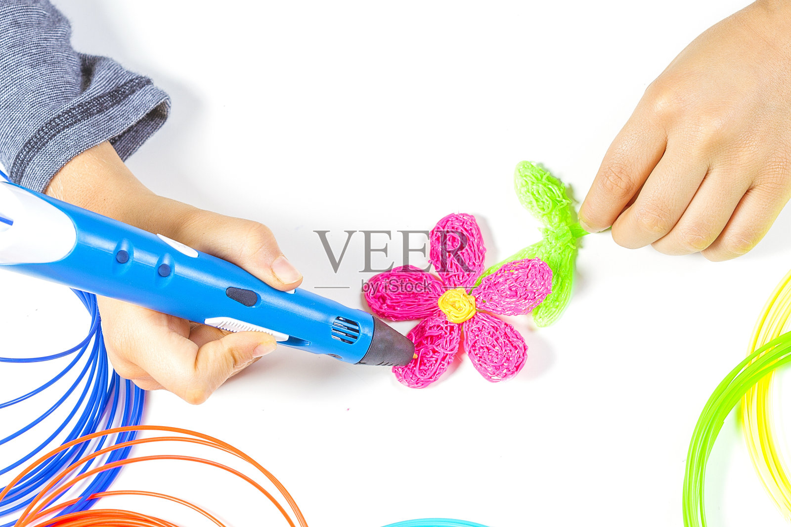 孩子手持蓝色3d打印笔，制作新项目照片摄影图片