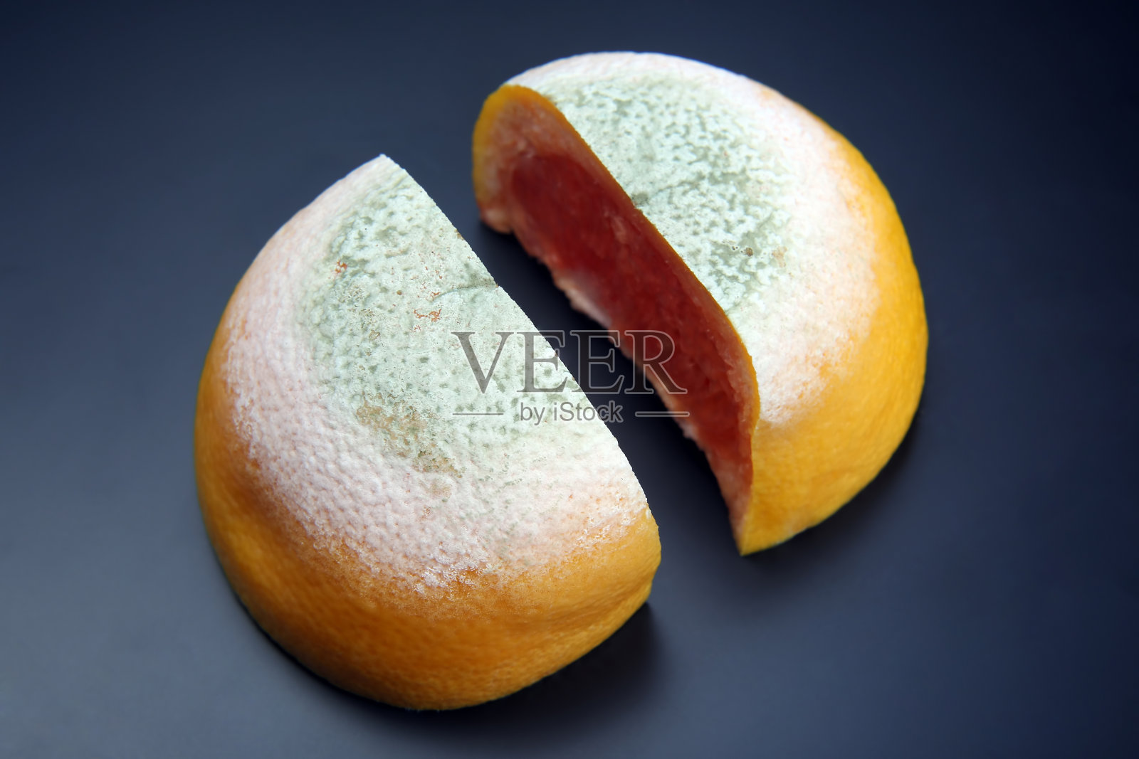 把腐烂的葡萄柚在深色的背景上切开照片摄影图片