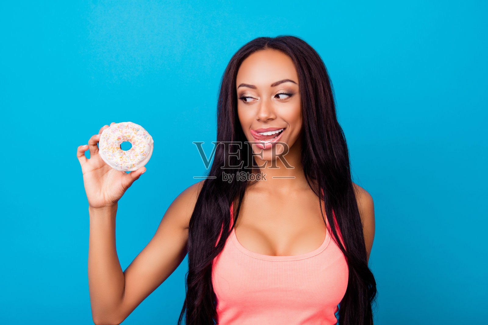 哇!保健、意志力、夏日、养生、理念。近距离的肖像欢快的风骚的非洲女人拿着美味的白色蛋糕，与粘舌头，在背心，看不健康的对待照片摄影图片