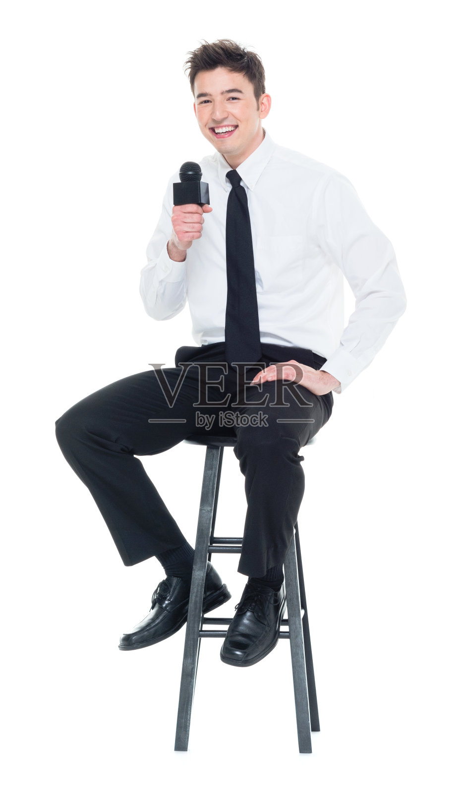 有魅力的年轻商人对着麦克风讲话并坐下照片摄影图片