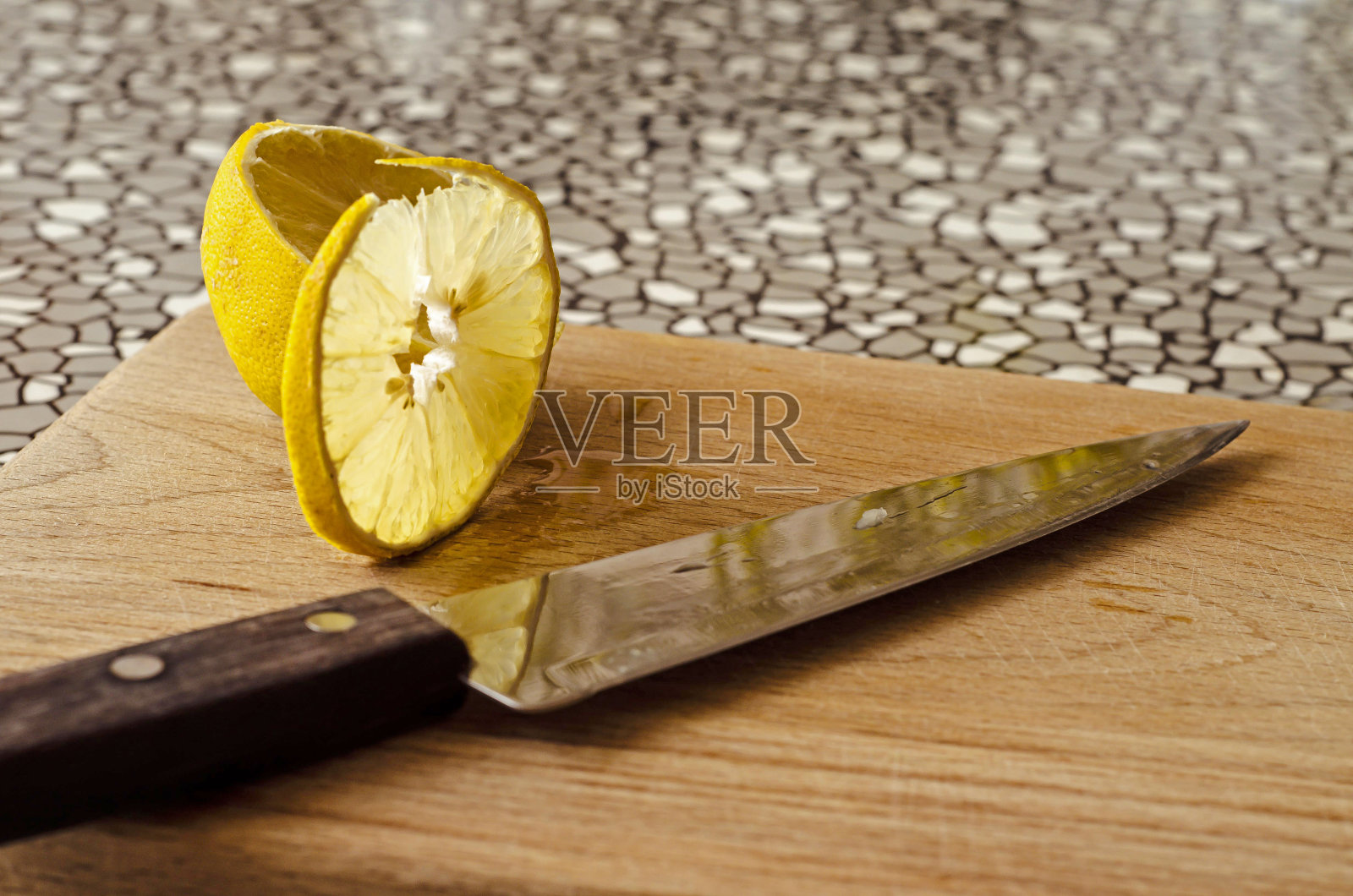 用刀在木板上切一片柠檬照片摄影图片
