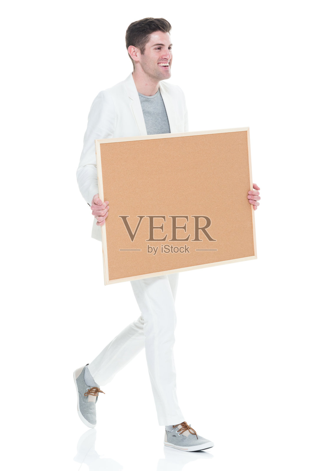 那个很帅的年轻人拿着棕色的牌子走着照片摄影图片