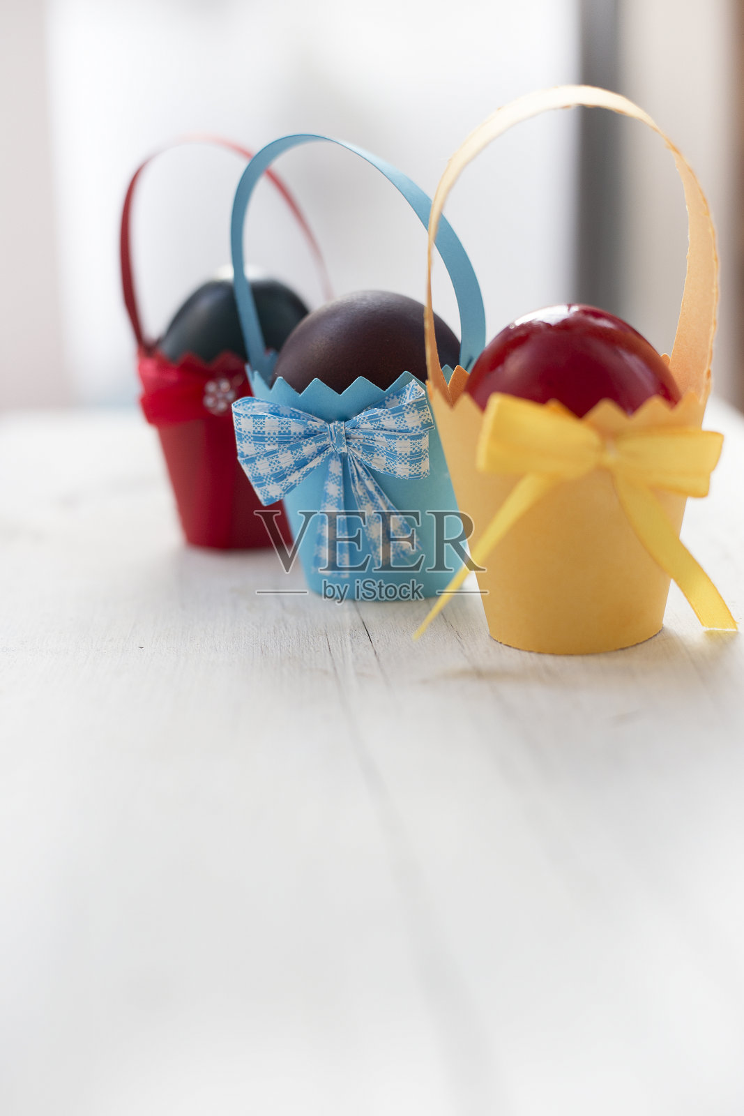 五颜六色的东方彩蛋在纸杯里翘曲。有选择性的重点照片摄影图片