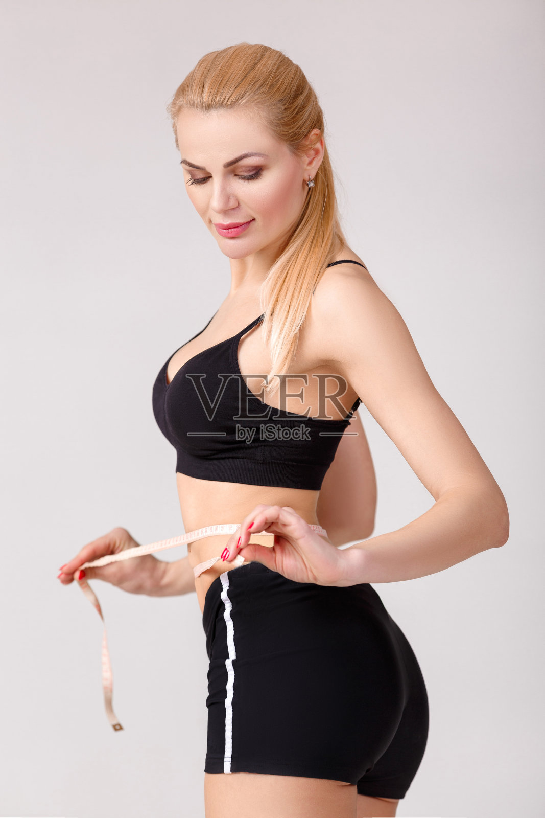 女人用卷尺量腰围照片摄影图片