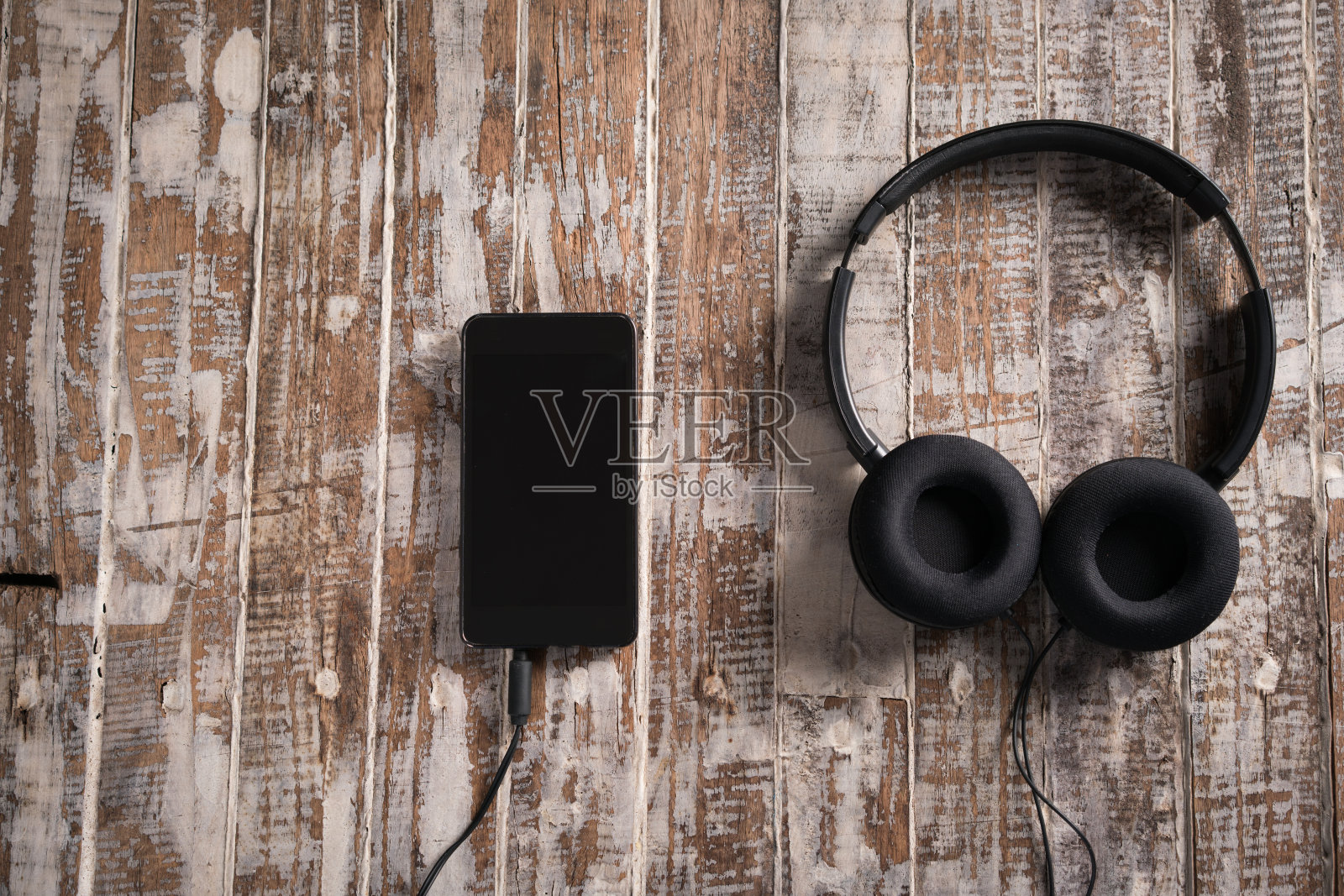 耳机和智能手机放在木头上照片摄影图片