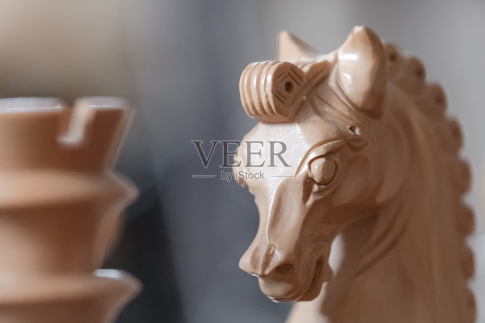 近距离的手雕刻，木制棋子看到旁边的一个焦点车。照片摄影图片