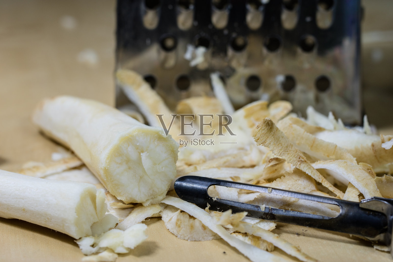 欧芹是用厨房刨丝器磨碎的。厨房台面，准备沙拉。黑暗的背景。照片摄影图片