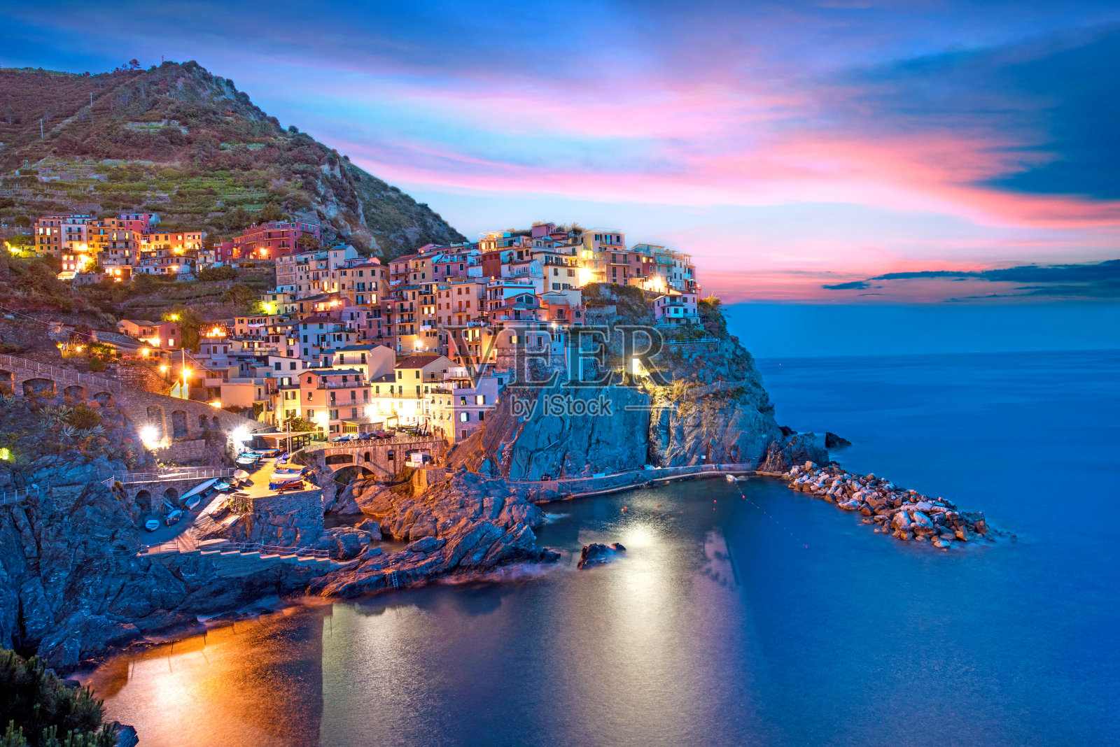 意大利利古里亚的马纳罗拉海滨岩石上色彩鲜艳的房子，神奇美丽的风景，在晚上的欧洲照片摄影图片