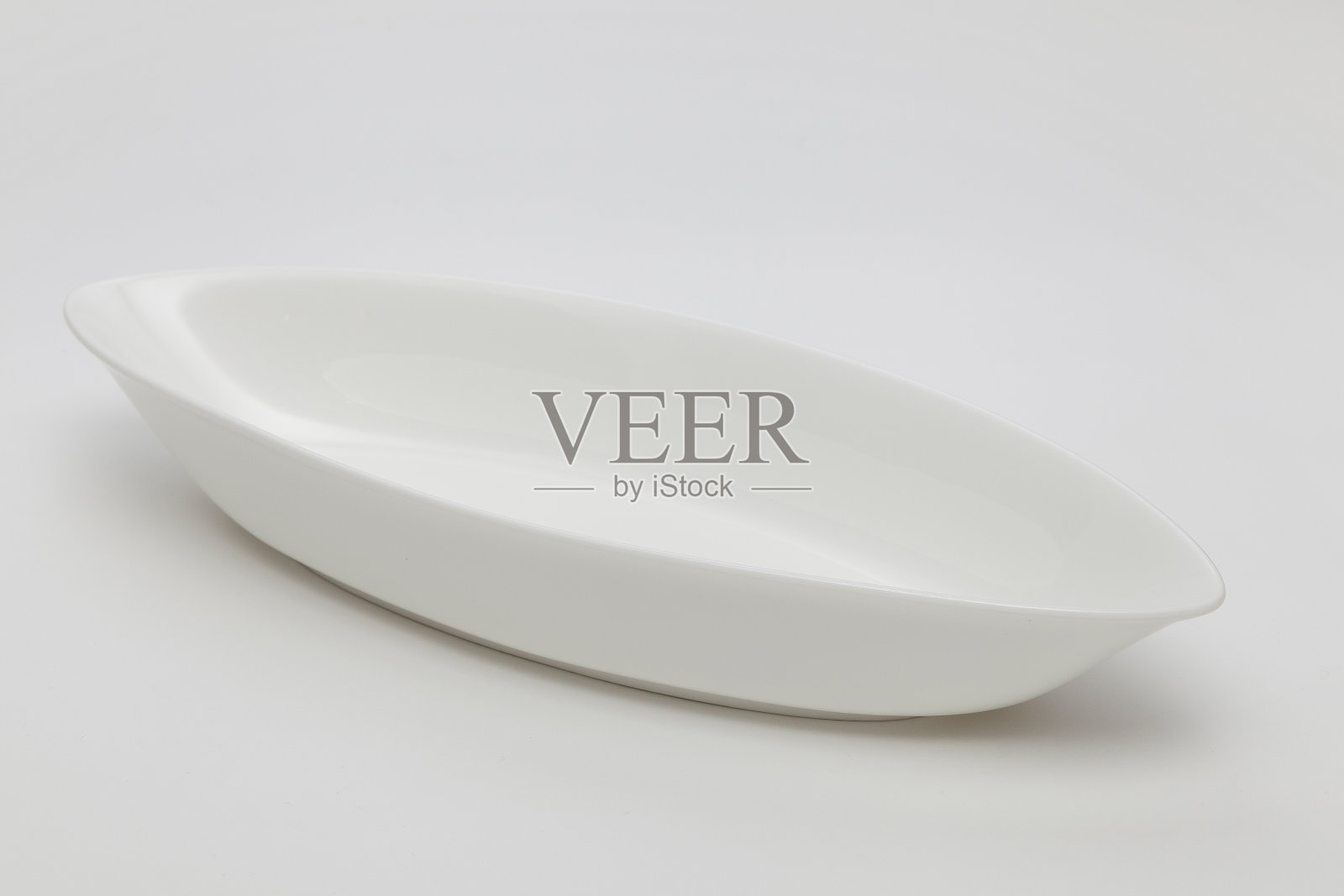 白色背景上的一个空的白色椭圆形盘子照片摄影图片