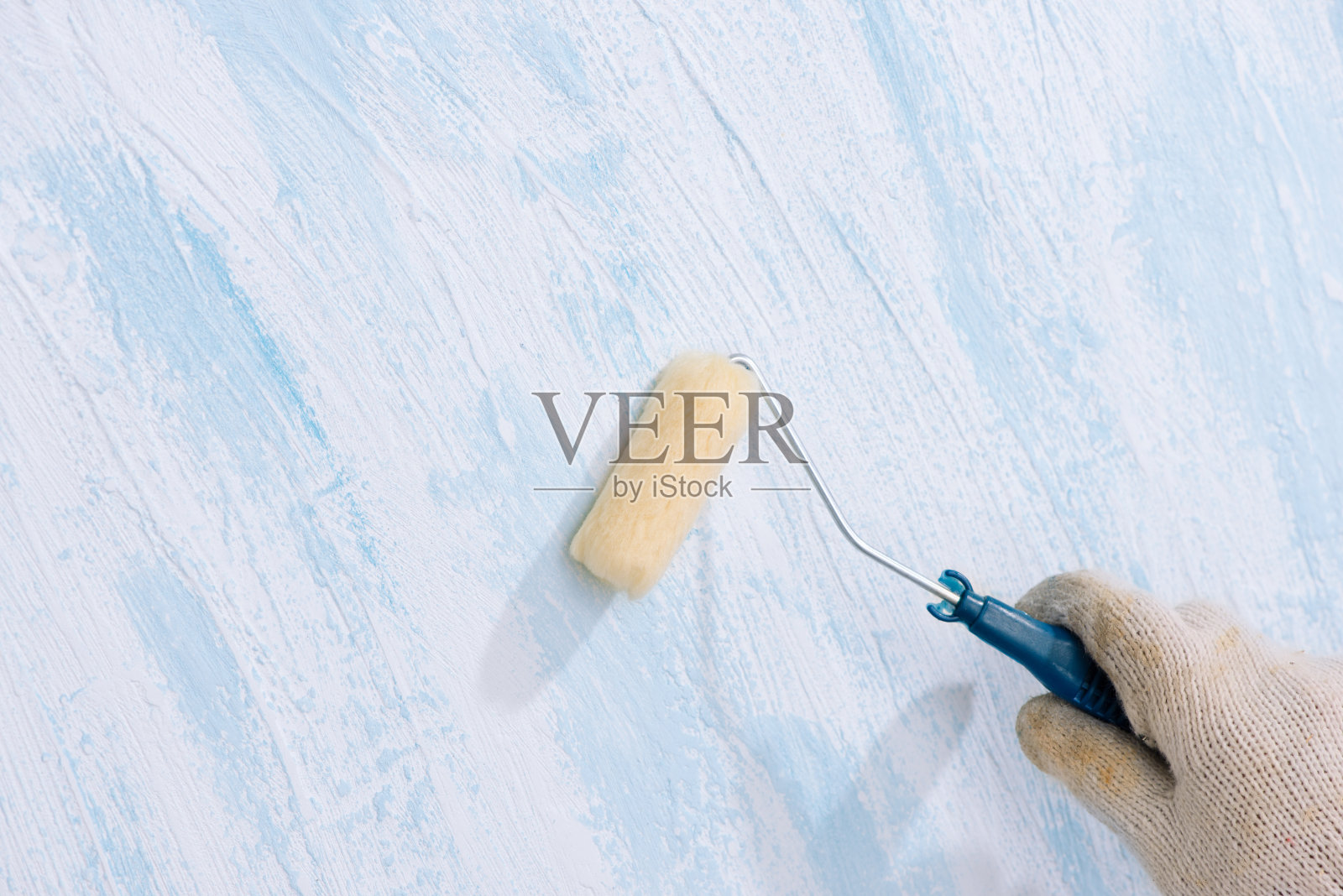 用滚筒刷在木质墙面上作画照片摄影图片