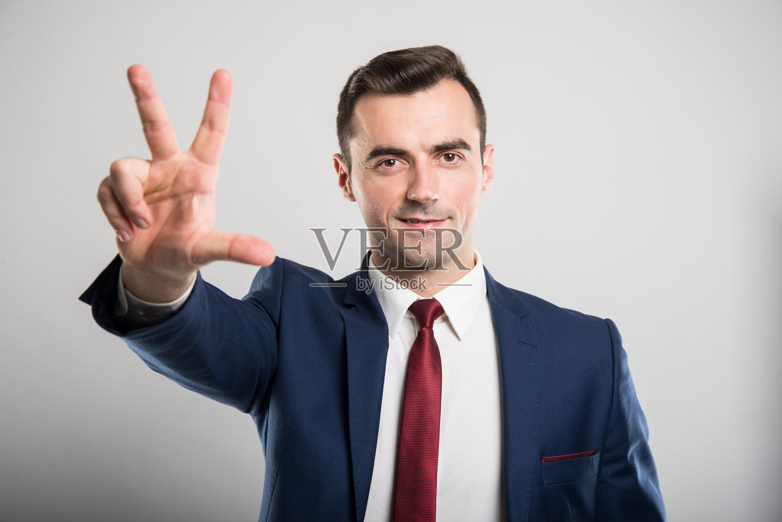 有魅力的商人，做着三号手势照片摄影图片