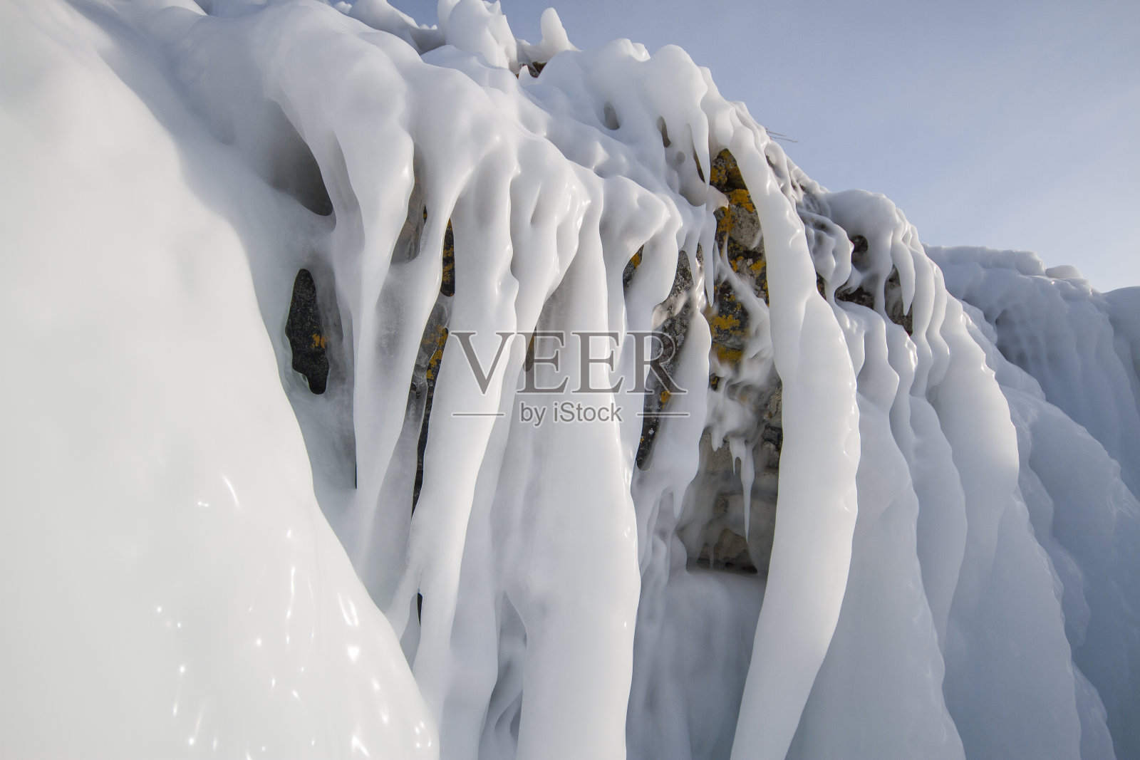 贝加尔湖是一个霜冻的冬日。最大的淡水湖。贝加尔湖被冰雪覆盖，寒冷和霜冻，厚厚的透明的蓝色冰。冰柱挂在岩石上。神奇的地方遗产照片摄影图片