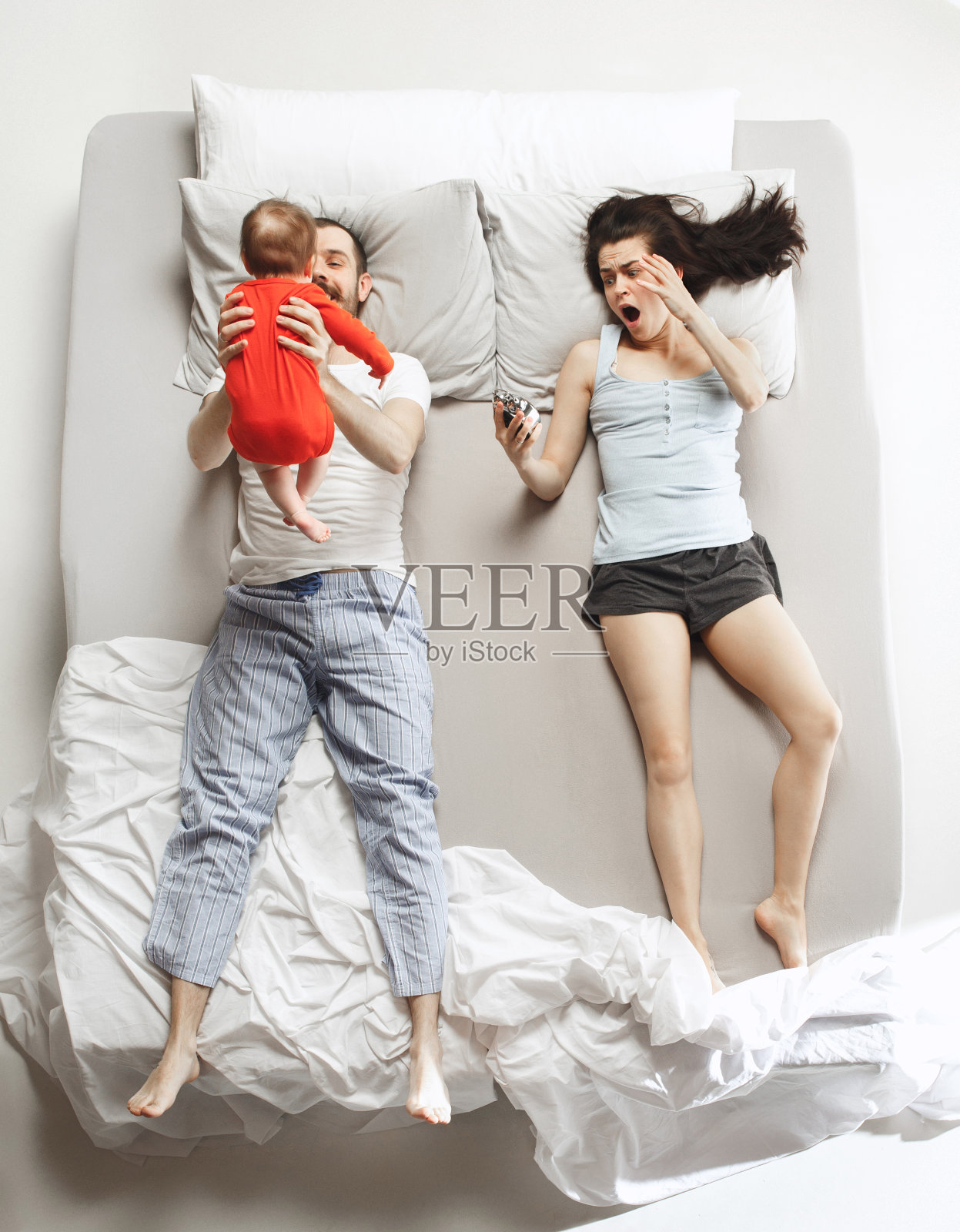 卧室里有一个新生儿的幸福家庭俯视图照片摄影图片