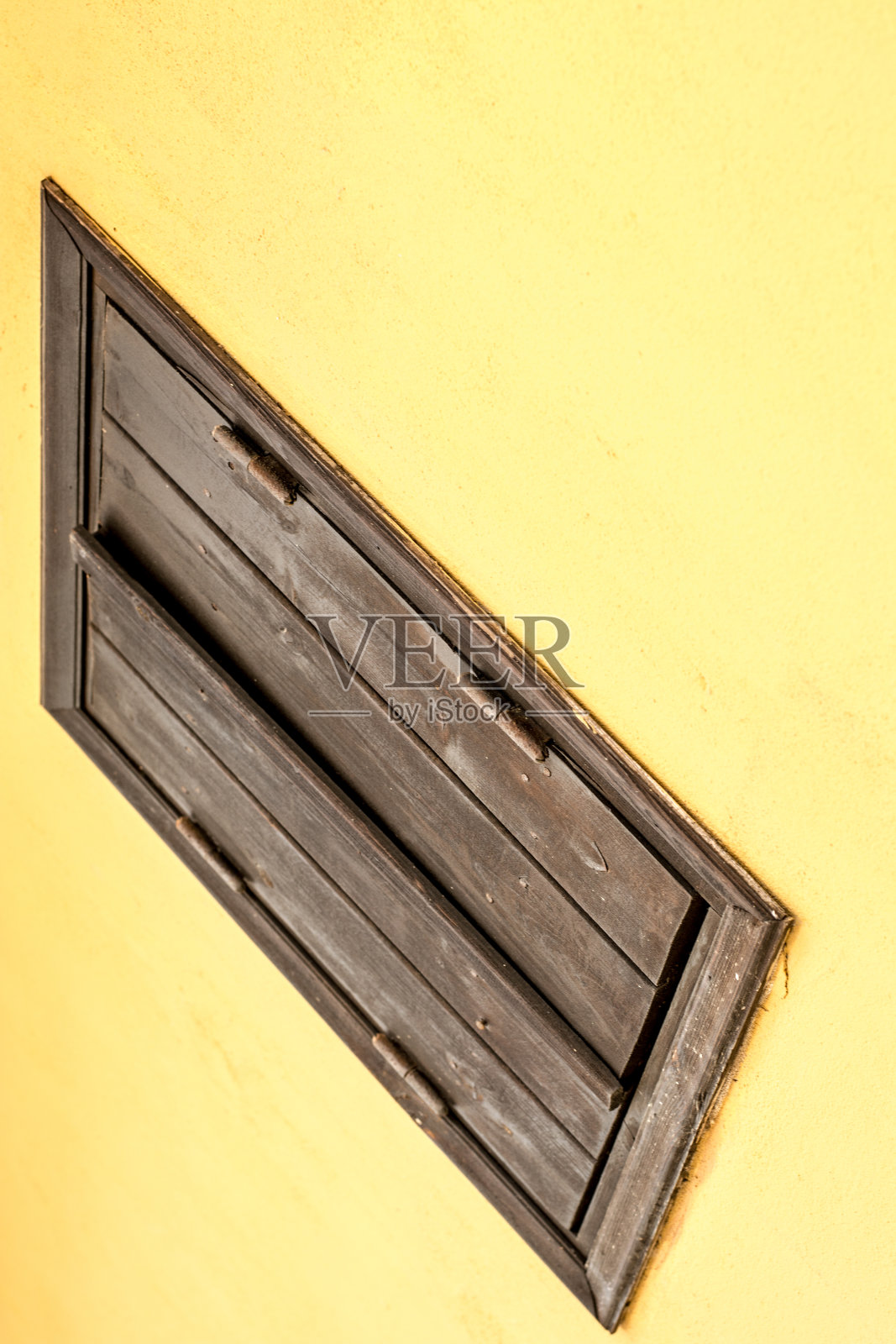 黄色的墙和棕色的木窗。抽象的成分照片摄影图片