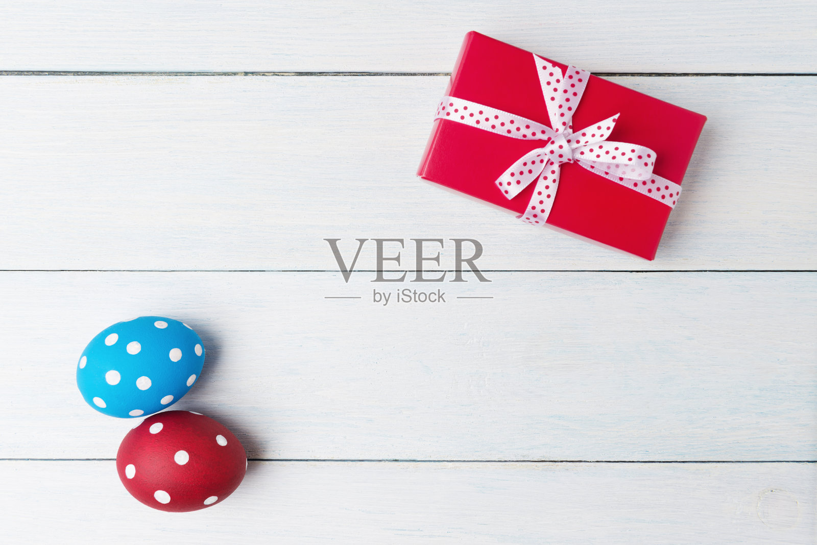 复活节彩蛋和礼物盒在白色的木制背景。照片摄影图片