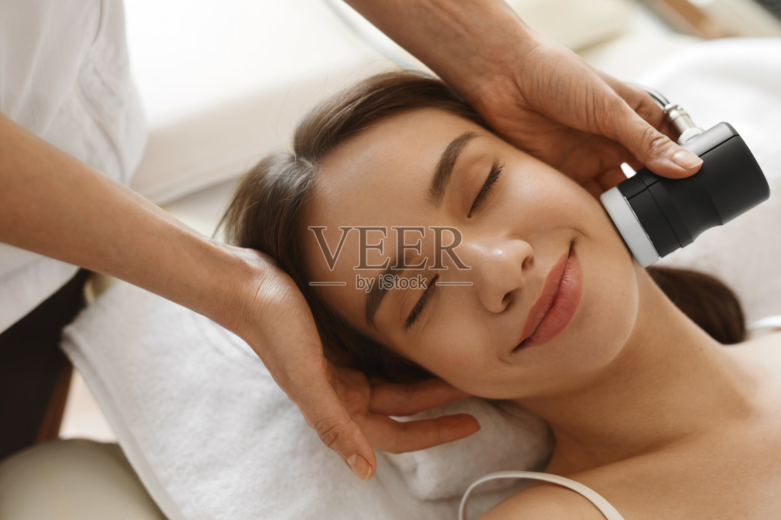 面部皮肤护理。在水疗中心做面部美容的女人照片摄影图片