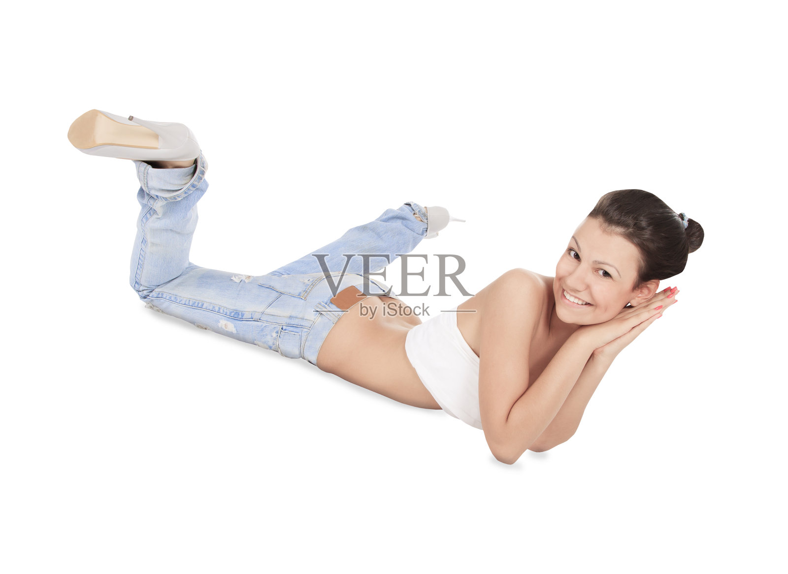 年轻的黑发女孩穿着破旧的牛仔裤在地板上摆姿势照片摄影图片