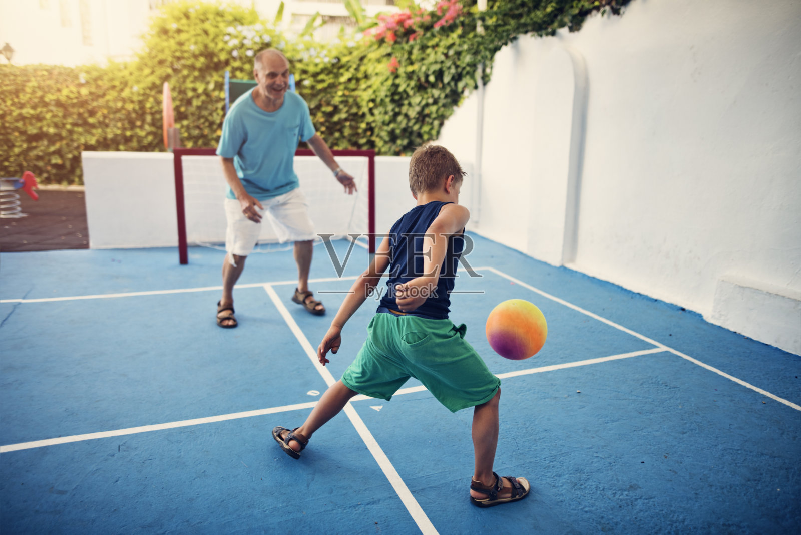 快乐的爷爷和孙子踢足球照片摄影图片