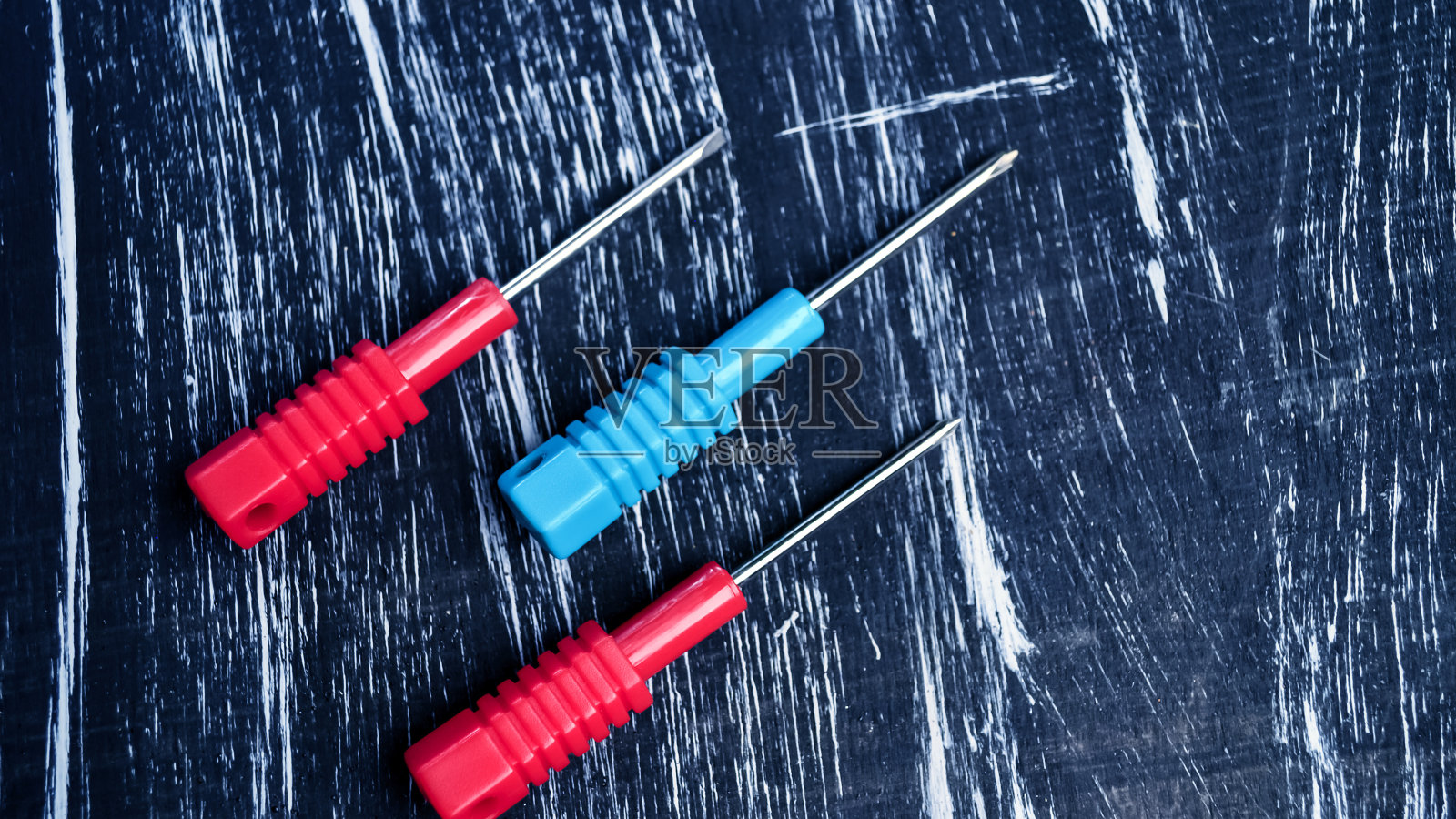 要修理的螺丝刀躺在桌子上。男人的家务。修复照片摄影图片