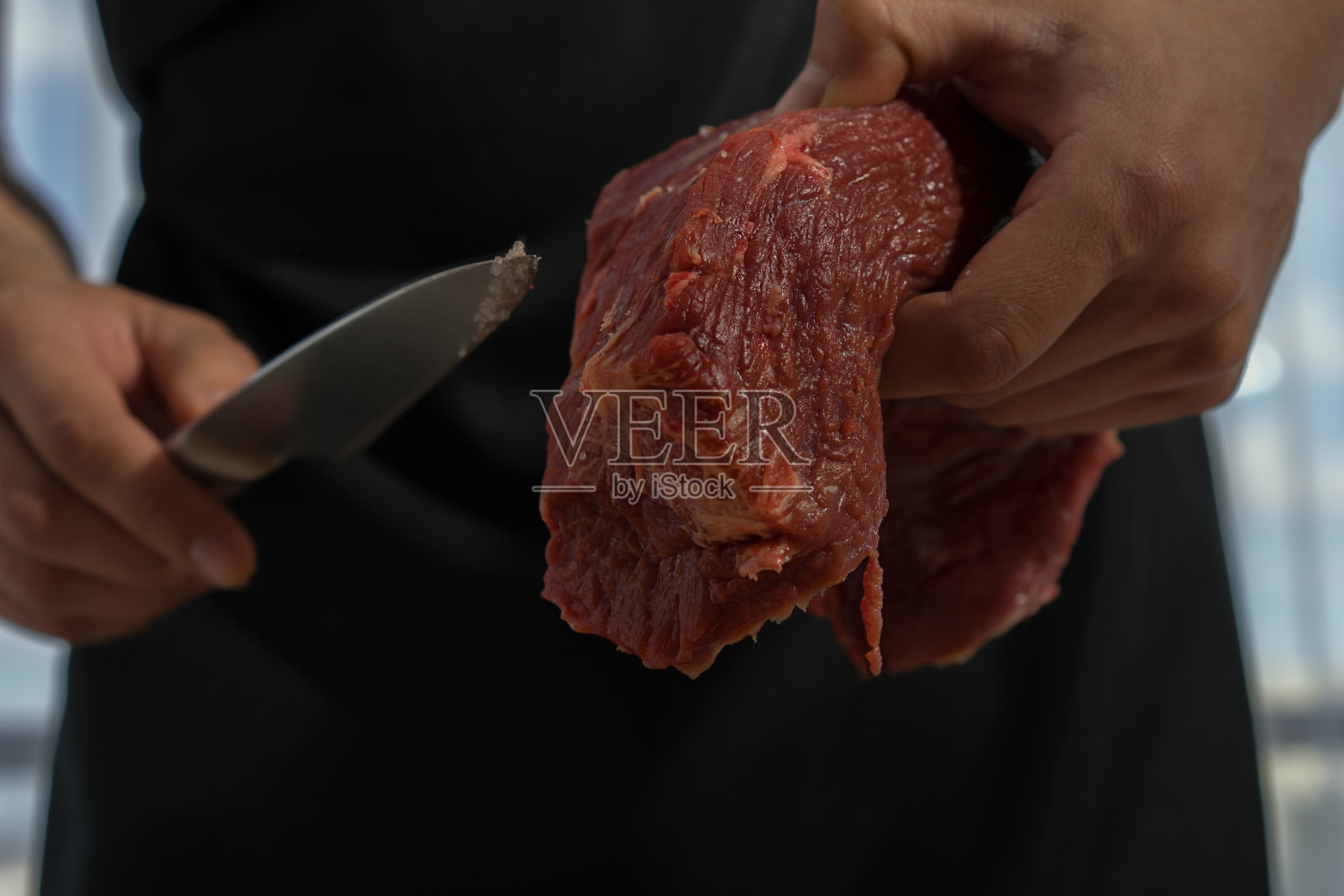 屠夫在厨房切牛肉照片摄影图片