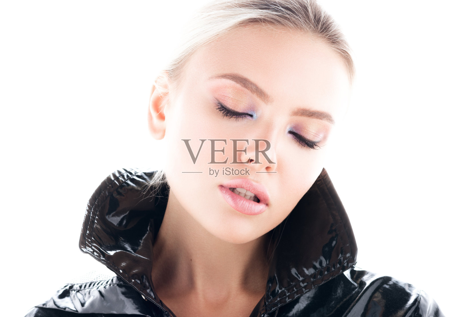 水平时尚特写年轻美丽的女人与闭上眼睛的肖像。时尚的黑色光泽外套照片摄影图片